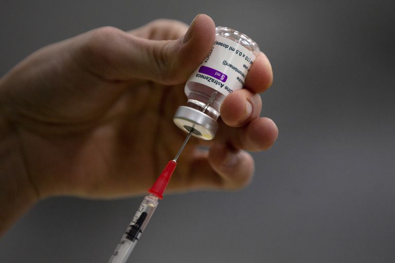 El órgano asesor de las vacunas retrasa la decisión de ampliar la de AstraZeneca a mayores de 55 años 2 Un sanitario extrae el suero de un vial de la vacuna de AstraZeneca.