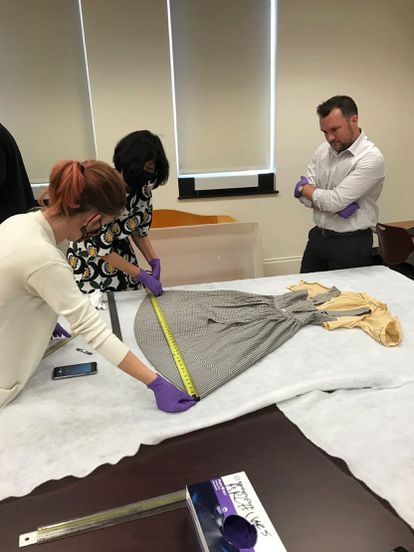 El vestido perdido de Dorothy estaba en una bolsa de basura 4 Los expertos del Museo de Historia Estadounidense del Instituto Smithsonian (de izquierda a derecha) Dawn Wallace, Sunae Park Evans y Ryan Lintelman examinan el vestido de Dorothy de 'El mago de Oz' encontrado en la Universidad Católica de América, en Washington.