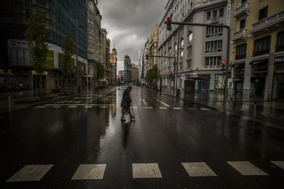 El tribunal más dividido declara inconstitucional el confinamiento 2 Una mujer cruza un paso de peatones en la Gran Vía de Madrid, el 23 de marzo de 2020, en pleno estado de alarma.
