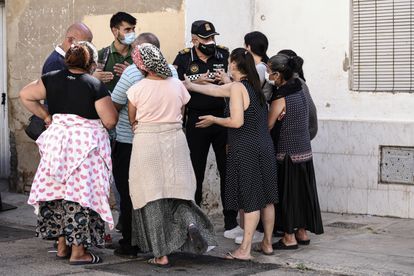 La presión vecinal retrasa el desalojo de 12 familias de dos edificios en riesgo de derrumbe en Valencia 3 Un policía conversa con los vecinos afectados por el desalojo en Valencia, un miembro del Sindicato Construimos Malilla y un trabajador social.