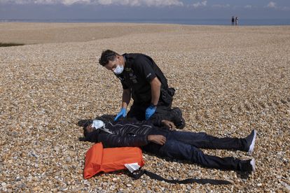 El canal de la Mancha se llena de pateras: “No tenemos nada que perder” 3 Un policía revisa el estado de un hombre colapsado en la playa de Dungeness el 4 de agosto de 2021.