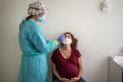 Personal médico del hospital Clínico San Carlos realiza una prueba PCR para detectar la covid-19 a una mujer embarazada.