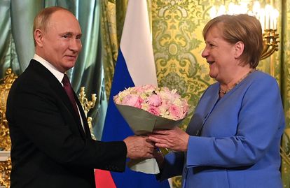 El presidente ruso, Vladimir Putin, recibe a la canciller alemana, Angela Merkel, con un ramo de flores durante su encuentro en el Kremlin, en Moscú.