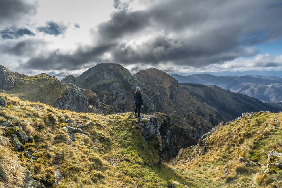 Los mejores senderos para descubrir a pie las cimas, bosques y rincones naturales de Navarra 6 Una joven observa el paisaje desde la cima de la montaña de Aiako Harria.