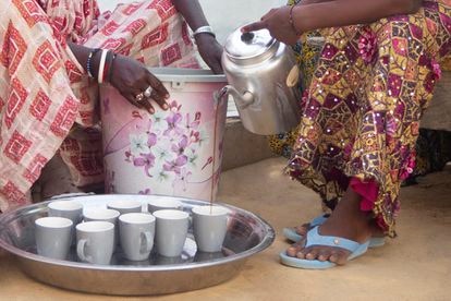 La caja de crédito de Fatou para las mujeres de su comunidad 3 Astou Faye y Aminta Diop preparan y sirven el café mientras llegan los asistentes.