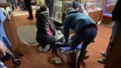 Un coche arrolla un desfile navideño en Wisconsin y mata a al menos cinco personas 2 Varias personas atienden a un herido tras el atropello.