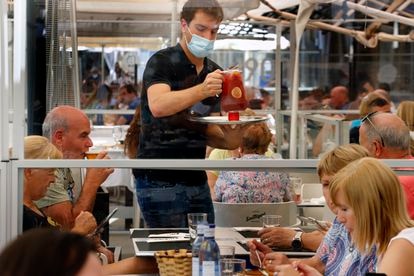 El Gobierno alivia las cargas de los nuevos ERTE estructurales: menos trámites y más ágiles 2 Un camarero sirve una sangría en un restaurante de Pamplona, el 12 de julio.