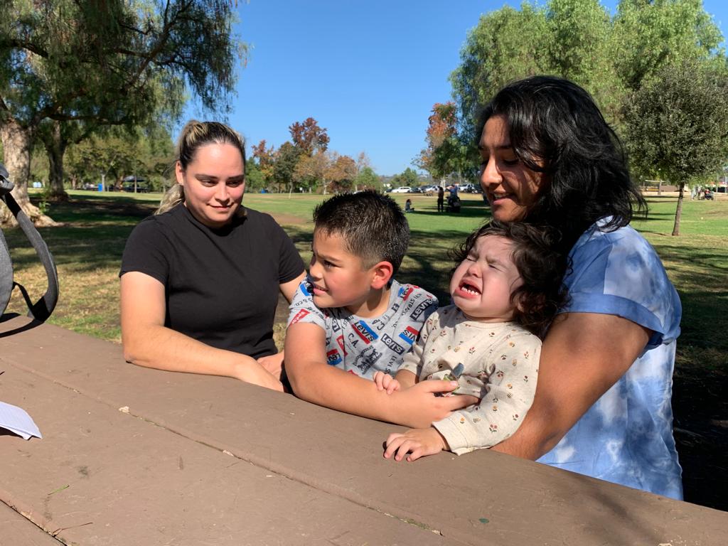 Le daban tres meses de vida: bebé hispana sobrevive de milagro a un peligroso síndrome y al COVID-19 2 Dos madres con sus hijos en un mesa de un parque